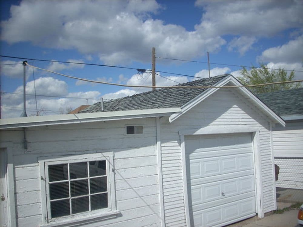 White garage with a skylight under a blue sky filled with fluffy clouds.